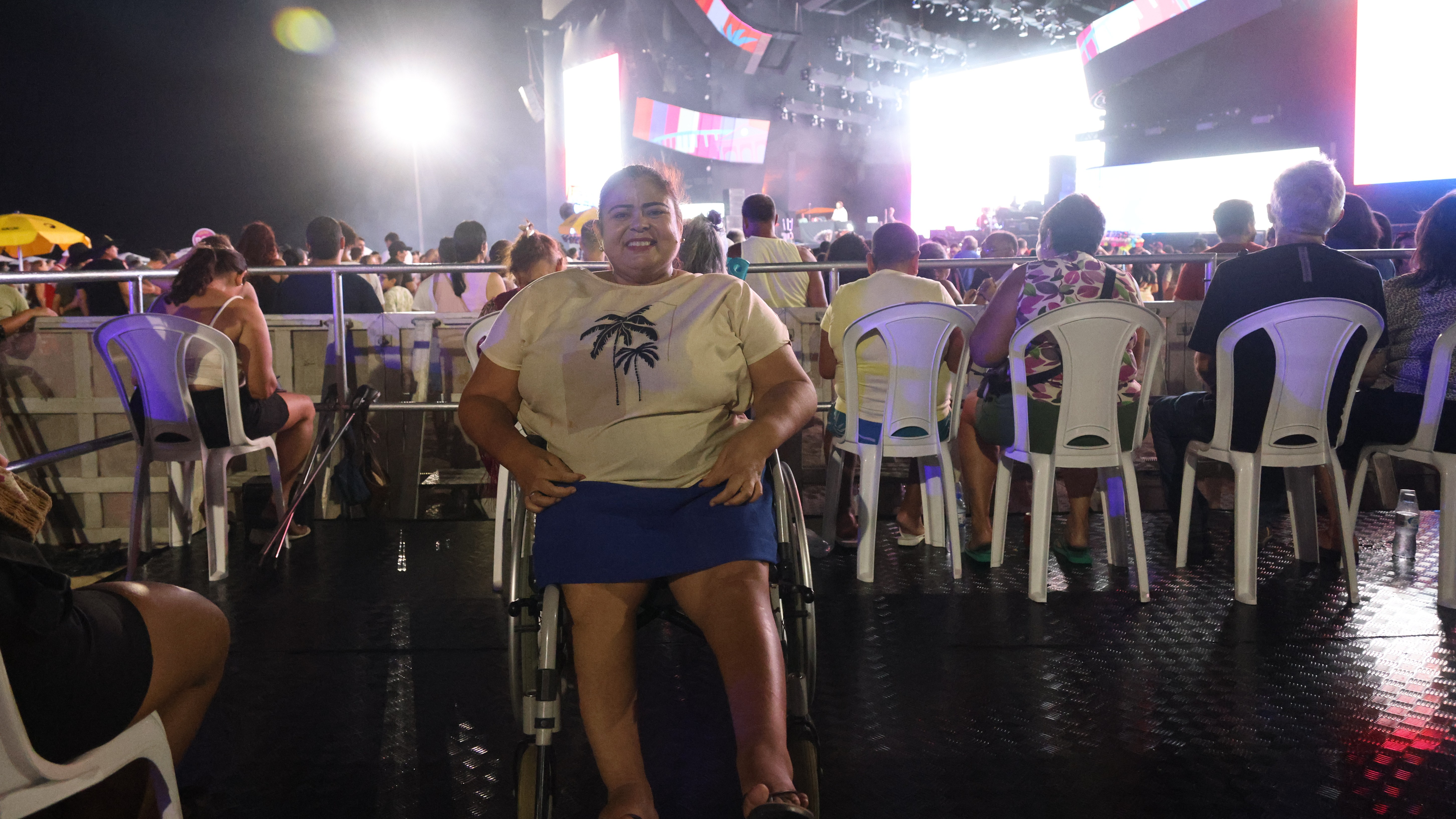 mulher cadeirante sorri para a foto no espaço PCD do último carnaval de Fortaleza no aterrino